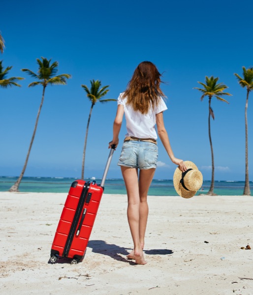 Viajante na praia com mala